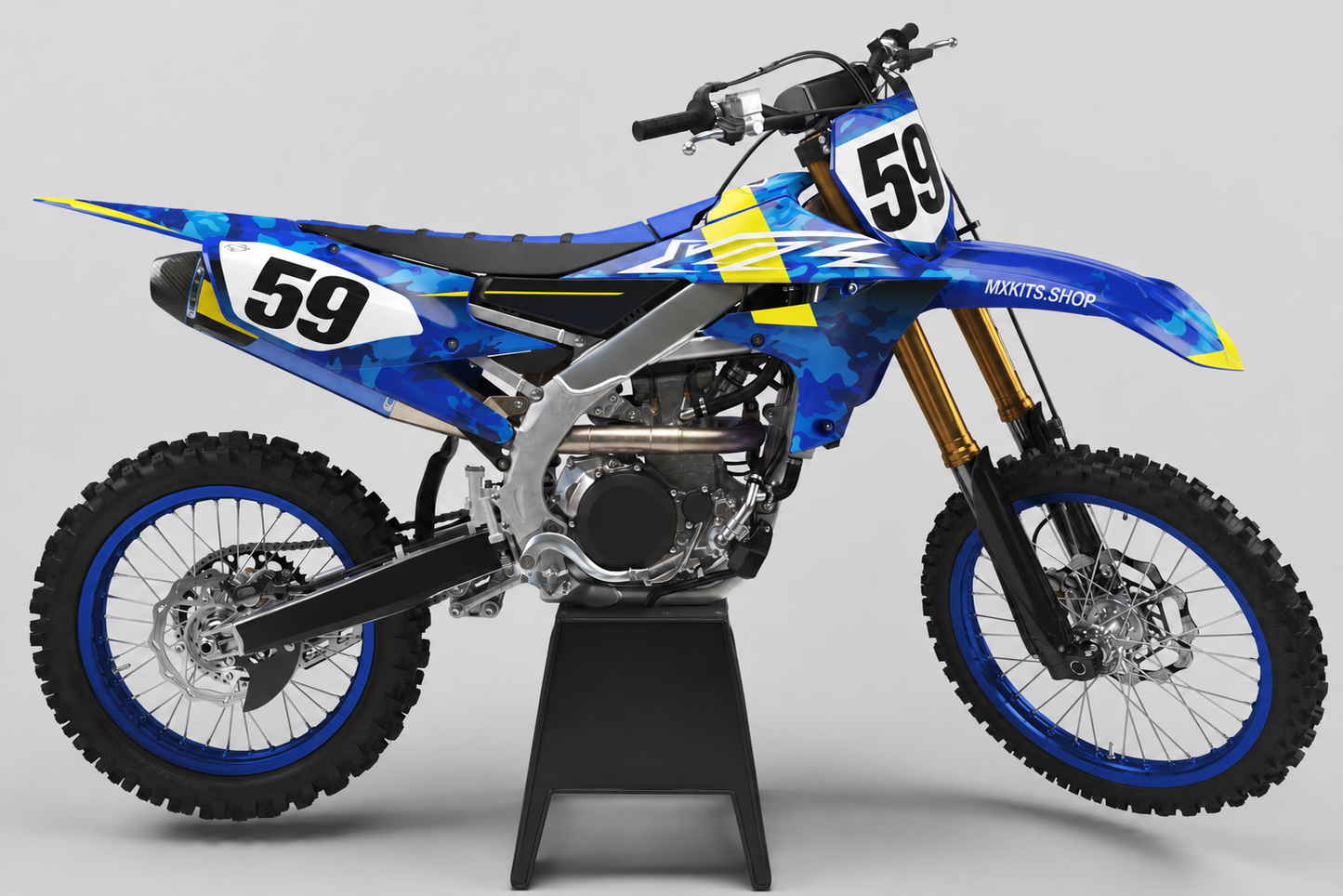Blaues Yamaha-Motocross-Motorrad ohne Sponsorenlogos mit Camouflage-Dekor und gelben Akzenten, MXKITS.SHOP-Logo und Startnummer 59