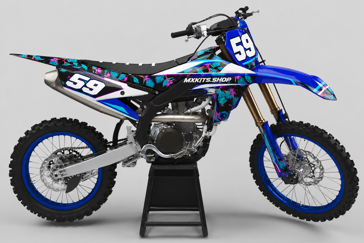 Blue Yamaha motocross bike wearing a tropical cyan and magenta graphics set with race number 59